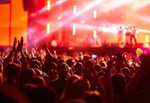 Crowd at concert with vibrant stage lights.