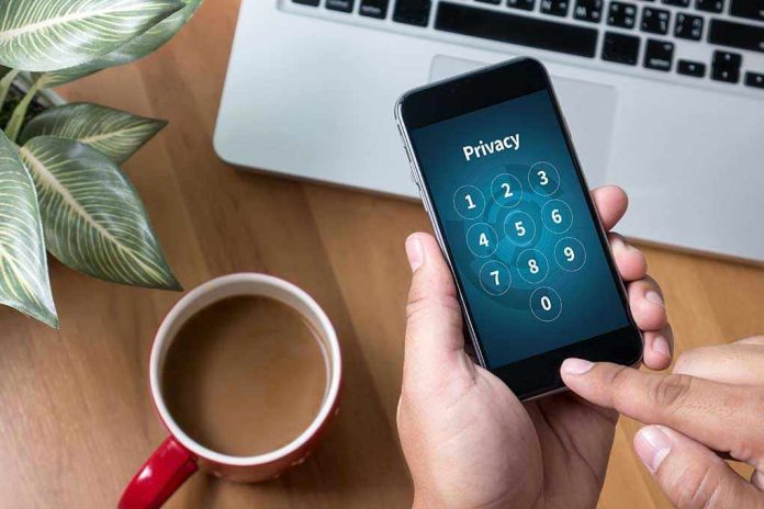 489314119 Typing privacy passcode on smartphone near laptop and coffee.