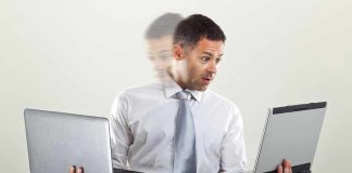 Man holding two laptops and looking surprised