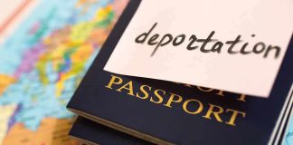 Stack of passports with a note labeled 'deportation' on top, placed on a map