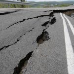 Road damaged by significant cracks and fissures.