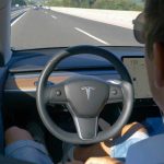 Person using autopilot in Tesla on highway.