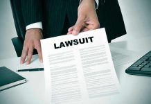 Person holding a document titled LAWSUIT in office.
