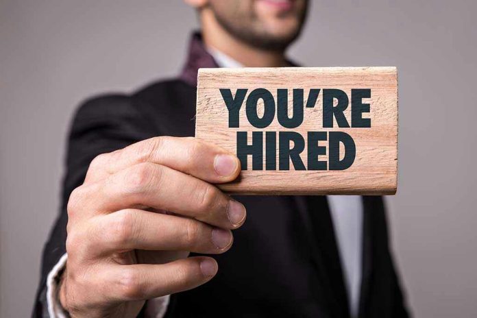 623590175 Person holding a Youre Hired sign.