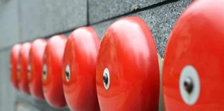 Row of red alarm bells mounted on a wall