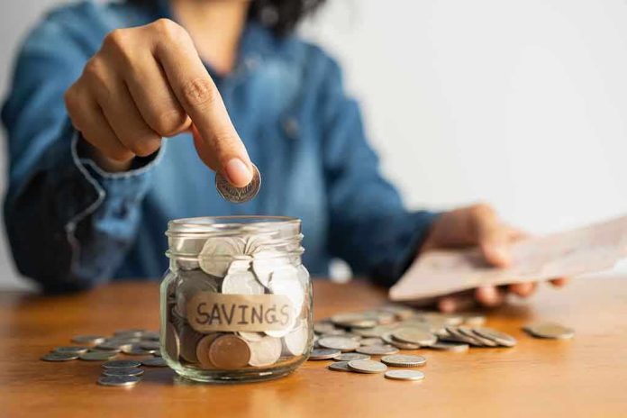 Person placing a coin into a savings jar labeled SAVINGS