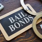 Bail bonds sign with handcuffs and stacks of cash