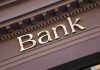Gold bank sign on building facade