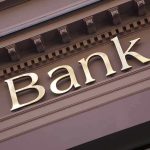 Gold bank sign on building facade