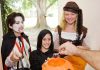 Children in Halloween costumes collecting candy from a house
